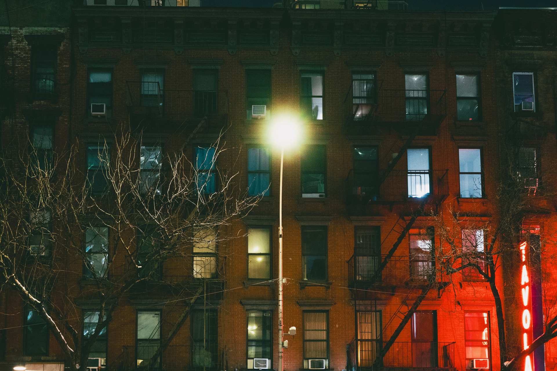 Office building exterior lit at night in the city with a dimly lit building facade